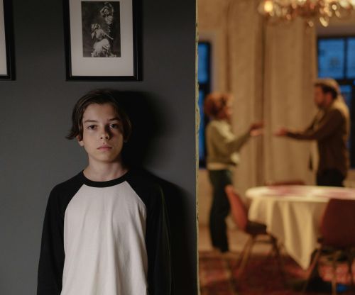 A boy stands in focus, while two adults argue in the background, depicting family conflict.