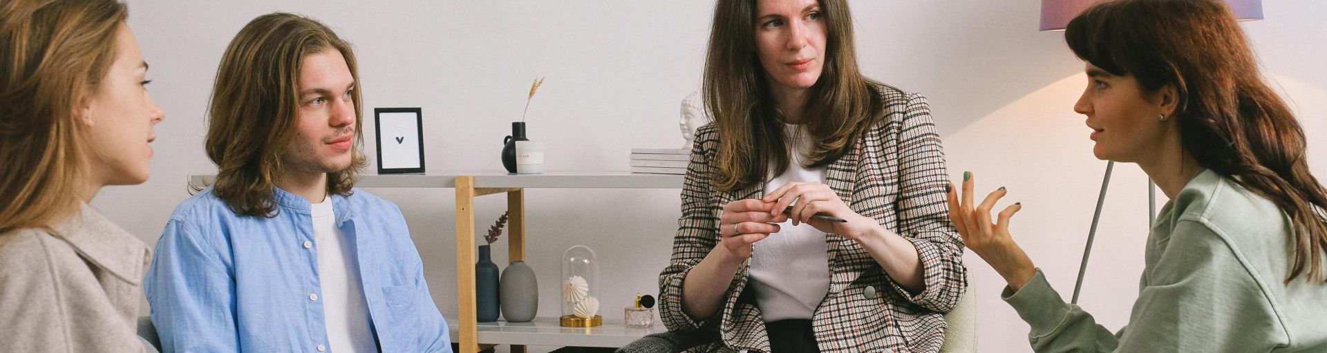 A group therapy session taking place indoors with an attentive counselor guiding the discussion.